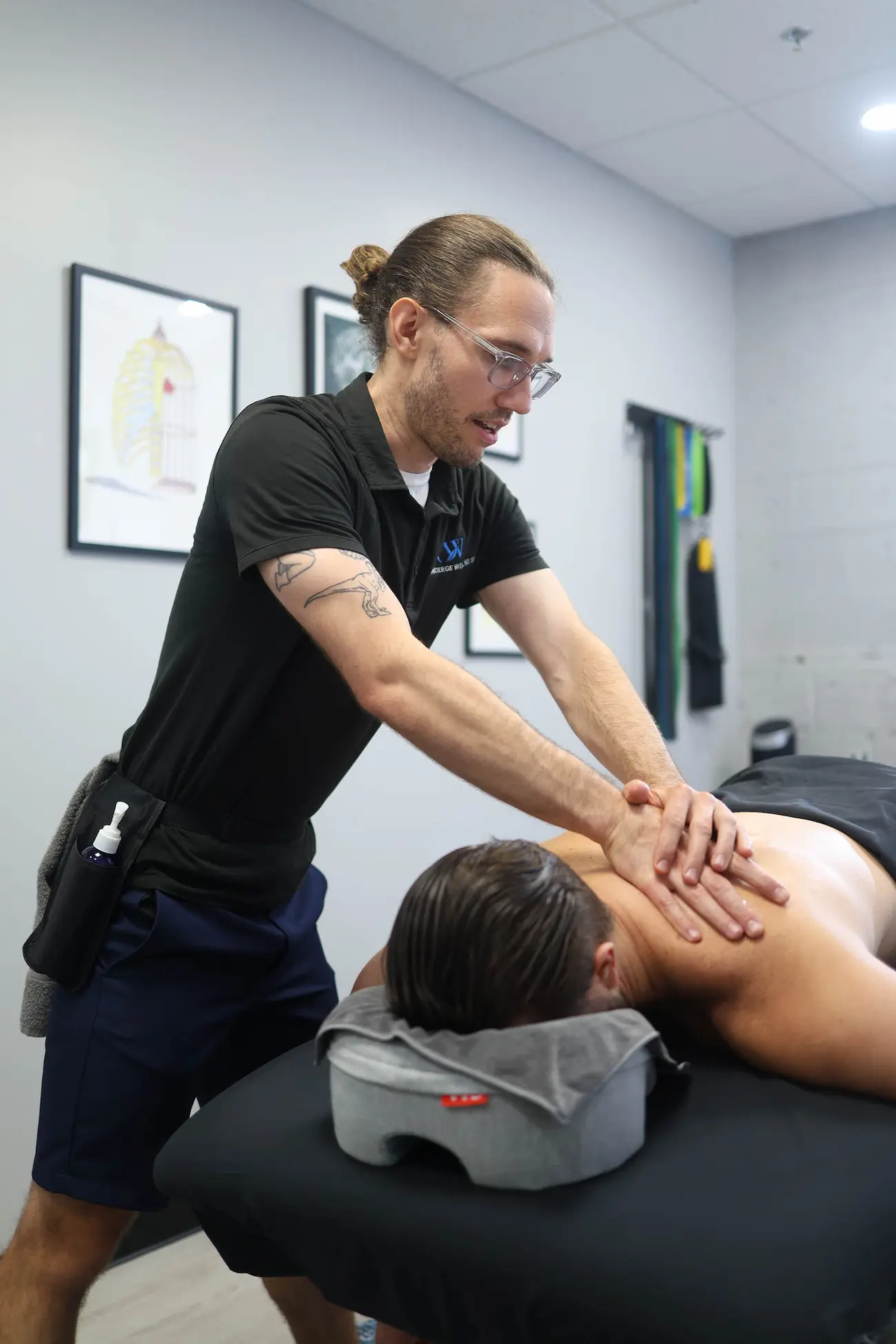Massage therapist applies pressure with his elbow to a patient's back
