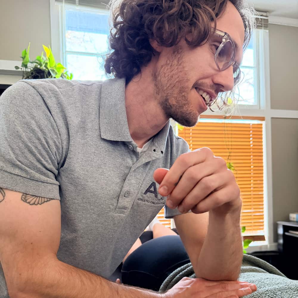 Massage therapist applies pressure with his elbow to a patient's back